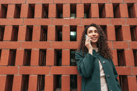 Young woman talking on mobile phone while walking in the city