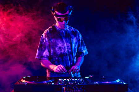 Club DJ playing music at party wearing sunglassesの写真素材