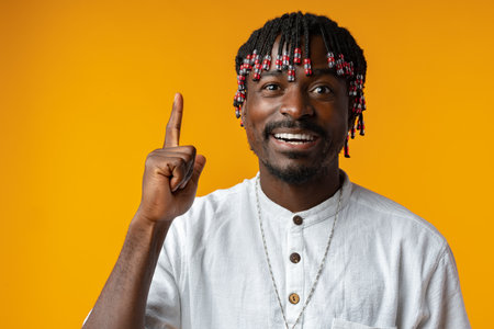 Young african man over yellow background pointing upwards having an idea