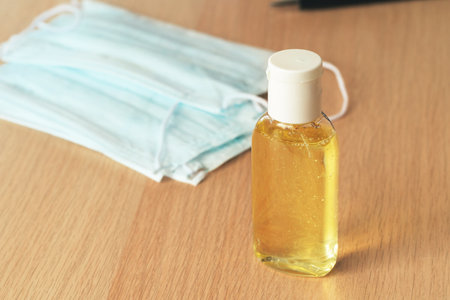 Working place table with small bottle of antibacterial sanitizerの写真素材