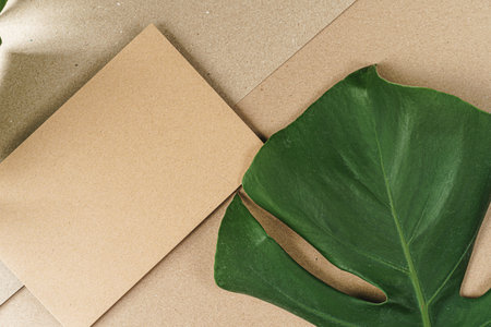 Flat lay craft paper card mockup with leaves