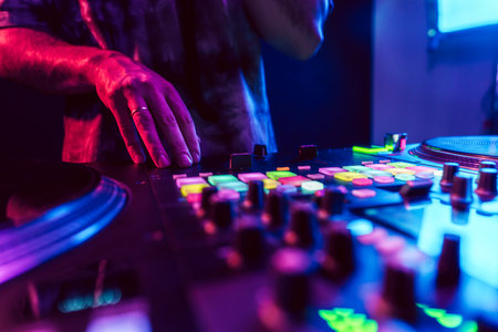 Close up of DJ hands on dj console mixer during concert in the clubの写真素材