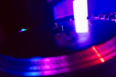 Close up of DJ mixing console in party lightの写真素材