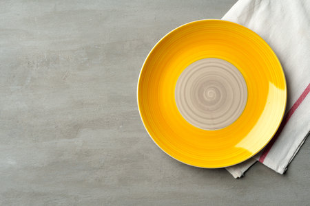 Top view of ceramic plate with table napkin on gray backgroundの写真素材