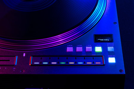 Close up of DJ mixing console in party light