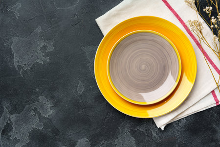 Top view of ceramic plate with table napkin on gray background