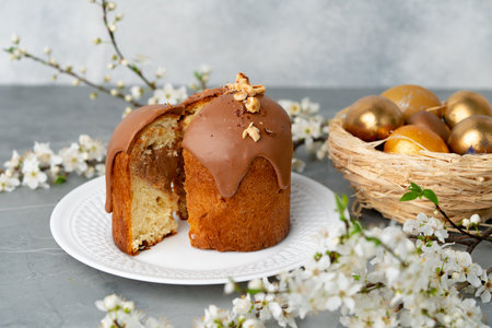 Cut Easter cake on plate decorated with spring flower branches