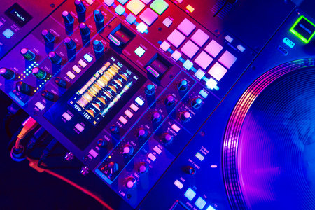 Close up of DJ mixing console in party lightの写真素材