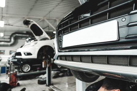 Car raised on car lift in car service shopの写真素材