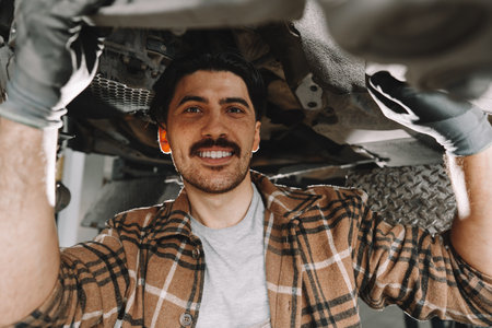 Auto mechanic repairs running gear of a car in car serviceの写真素材