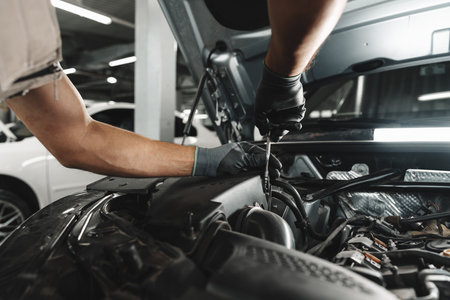 Close up of mechanics hands repairing car engine in car serviceの写真素材