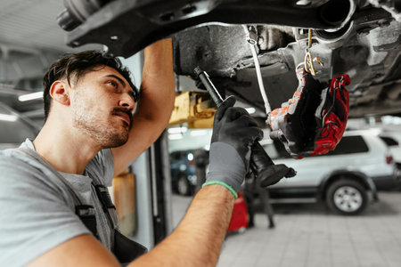 Auto mechanic repairs running gear of a car in car service