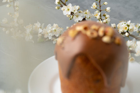 Ester cake with chocolate topping and nuts on gray background
