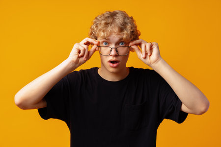 Young man over yellow background with surprise facial expressionの写真素材