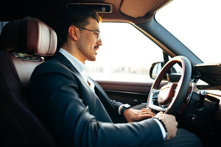 Young businessman in elegant suit driving luxury carの写真素材