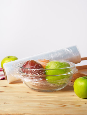 Bowl of fresh fruit in a glass bowl covered with cling filmの写真素材