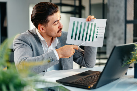 Businessman working in office with charts and graphsの写真素材