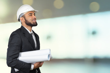 Confident smiling portrait of black architect holding plans isolated in studioの写真素材