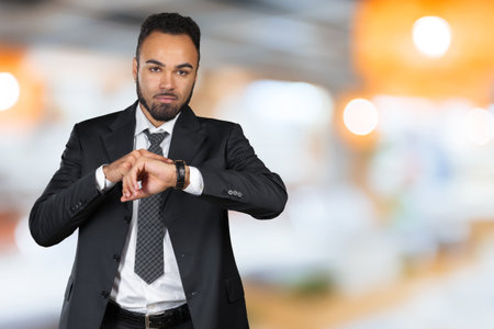 Handsome African American young man looking at watch. Copy spaceの写真素材