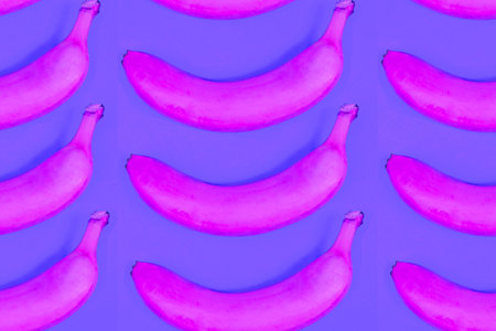 toy yellow plastic banana on red colored backgroundの写真素材