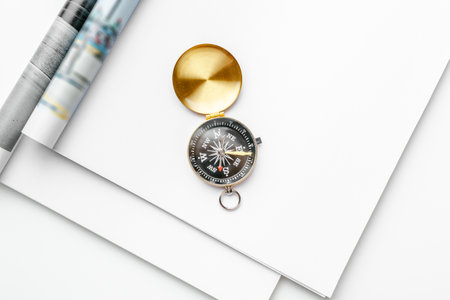 Open blank magazine page for copy space with a golden compass on white tableの写真素材