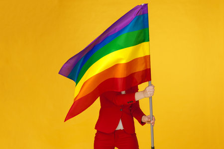 Rainbow flag. Woman holding and waving large LGBT flagの写真素材