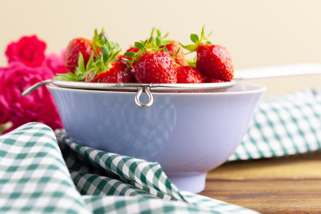 Heap of fresh strawberries in ceramic bowl on rustic backgroundの写真素材