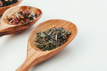 leaf tea in a wooden spoon isolated on white backgroundの写真素材