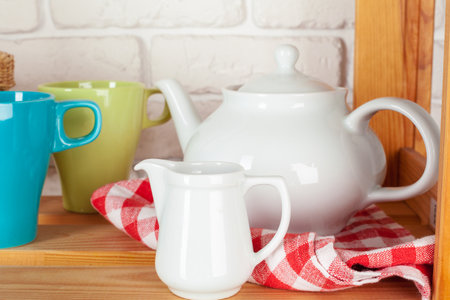 Kitchen utensils and dishware on wooden shelfの写真素材