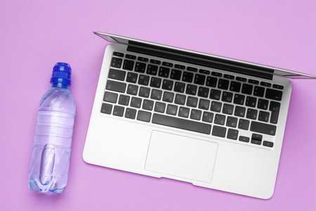 bottle of water on office table near laptopの写真素材