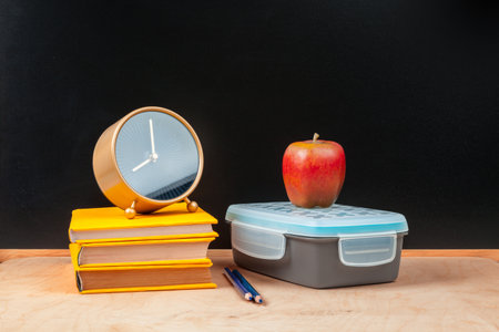 Stack of books with apple and pencil on tableの写真素材