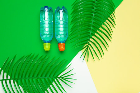 Transparent liquid bottle with tropical palm leaves, top viewの写真素材