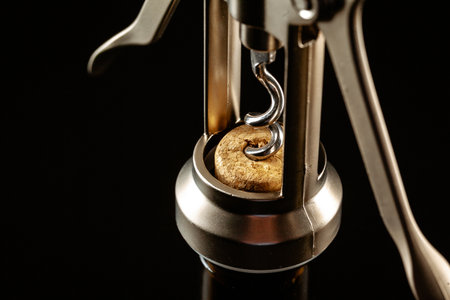 Bottle of wine and corkscrew over dark background