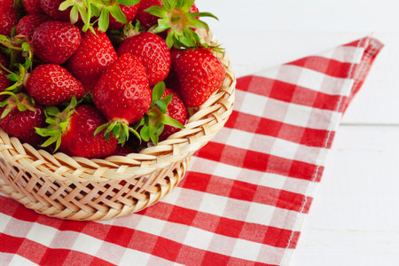 Fresh strawberry in basket on wooden backgroundの写真素材