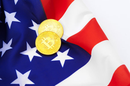 Bitcoin physical coins on American flag background with dollars