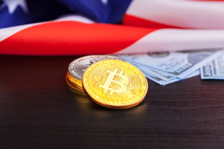 Bitcoin physical coins on American flag background with dollarsの写真素材