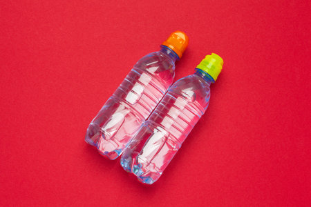 Plastic bottles with pure water on red background top viewの写真素材