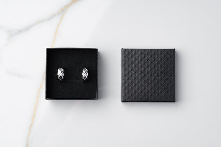 Golden earrings and jewelry box on table close up