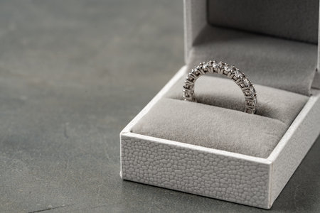 Golden ring in jewelry box on gray background