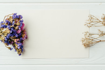 Blank sheet of paper with flower branch on wooden backgroundの写真素材