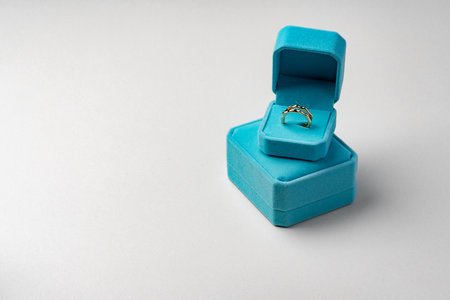 Golden ring in jewelry box on gray backgroundの写真素材