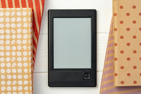 E-book reader device on background of paper booksの写真素材