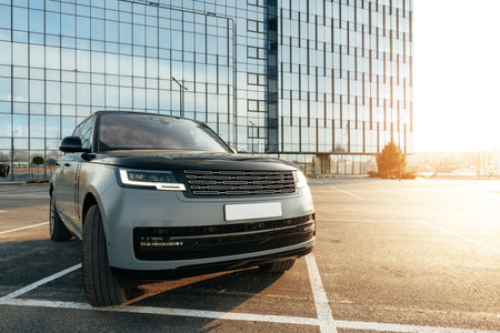 Luxury SUV car parked against a background of glass buildingの写真素材