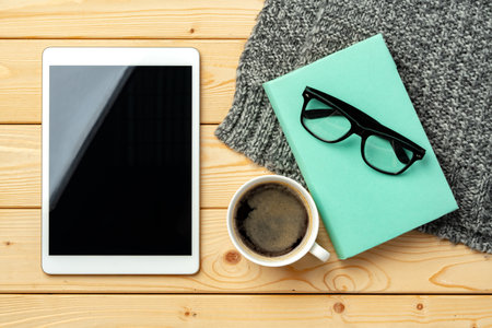 Top view of wooden table with white digital tablet with black screen on itの写真素材