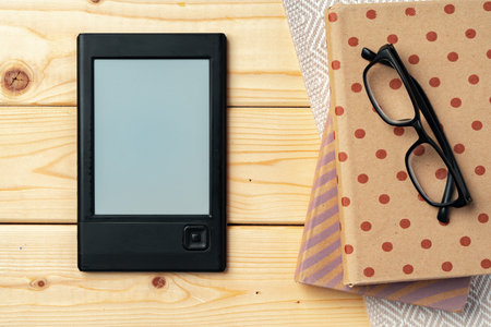 Portable e-book reader on wooden background top viewの写真素材