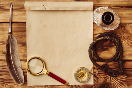 Old paper on brown wood background with featherの写真素材