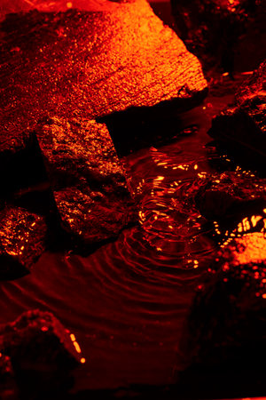 Stones and water illuminated by colored lightの写真素材