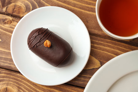 Delicious chocolate cake in white plate on wooden table backgroundの写真素材