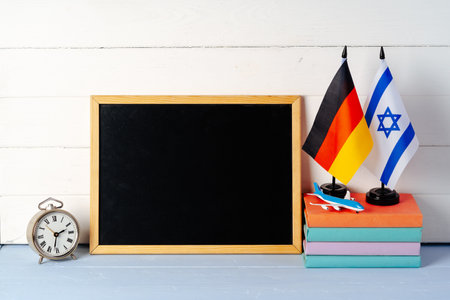 Blank blackboard with books and flags of Germany and Israelの写真素材