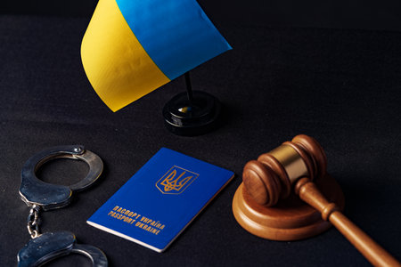 Ukrainian flag and handcuffs on black background, concept of crime and justice in the countryの写真素材